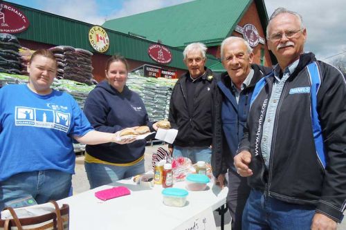 L-r, Yolanda Emmert and Vicki Babcock serve up burgers to Sharbot Lake and District Lions Andy Vandersande, John Richter and Bill Zwier at the Team Kylie Relay for Life fundraiser in Sharbot Lake on May 17